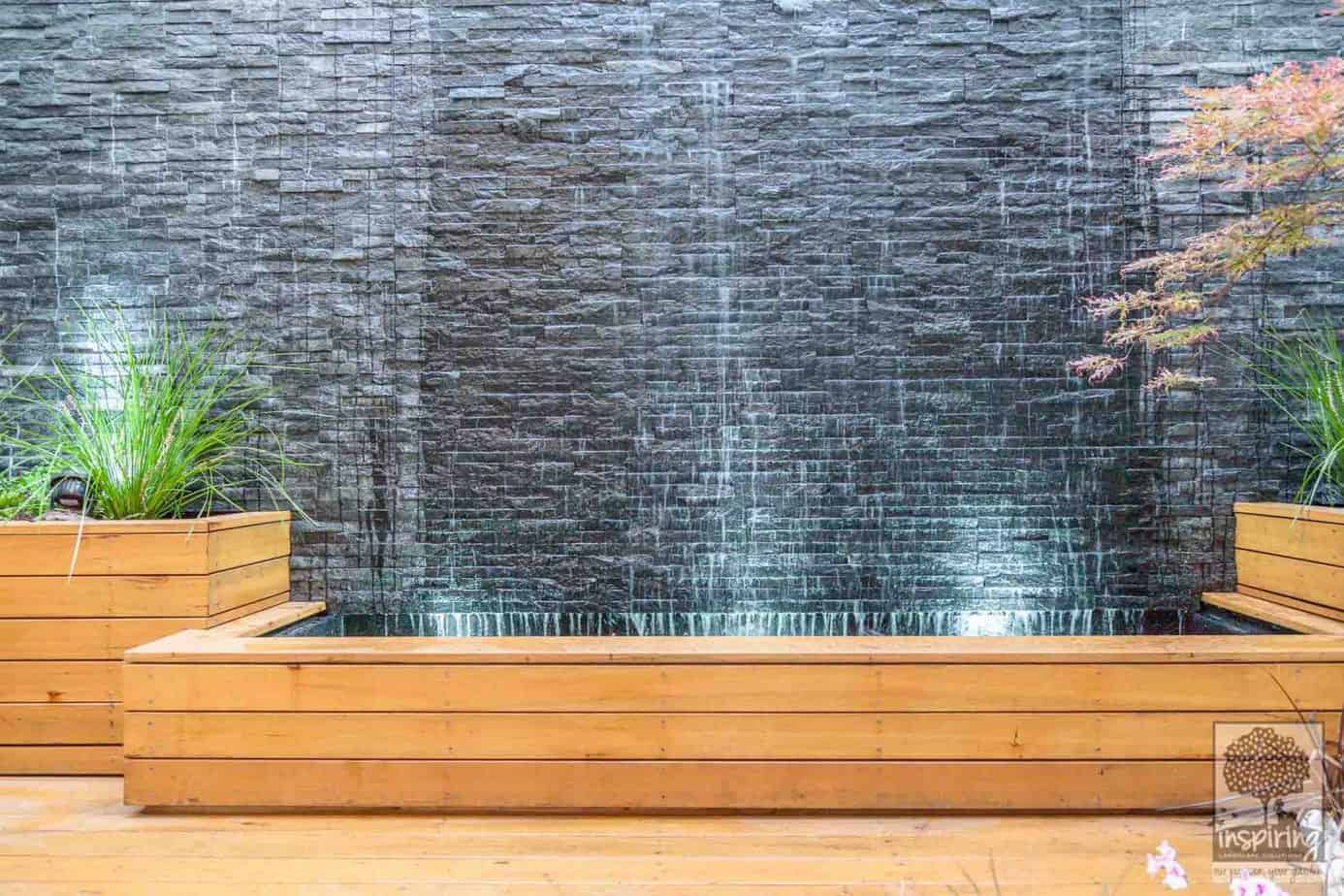 Closeup view of the retaining garden beds and slate wall used to create the water feature in the courtyard garden