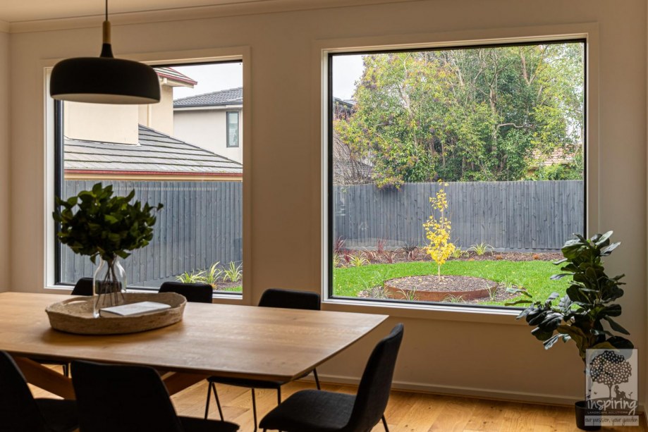 View of gingko tree and grasses in backyard from dining area in Burwood landscape design by Parveen Dhaliwal