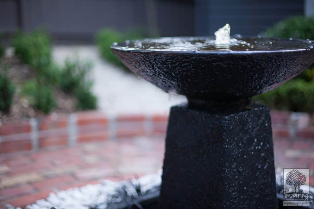 Black circular water feature in Blackburn garden design by Parveen Dhaliwal