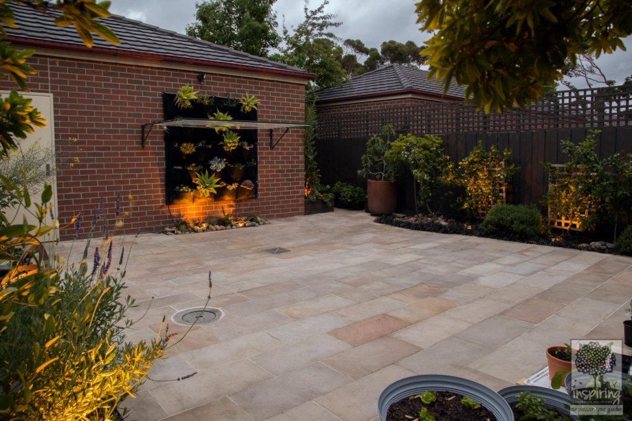 Bundoora courtyard garden design with sandstone paving lit at night