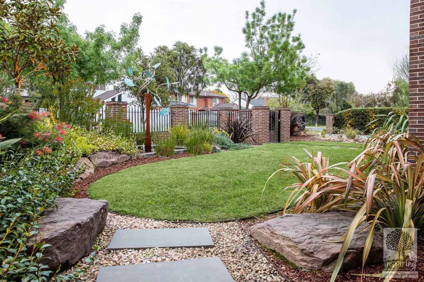 Glen Waverley front garden design with lawn, large rocks and mixed planting of exotics and native Australian plants