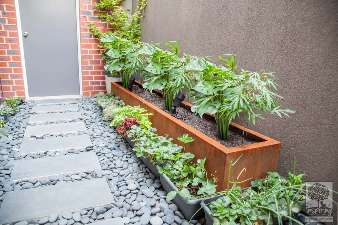 Rusty metal fence planter box used in Kew garden design