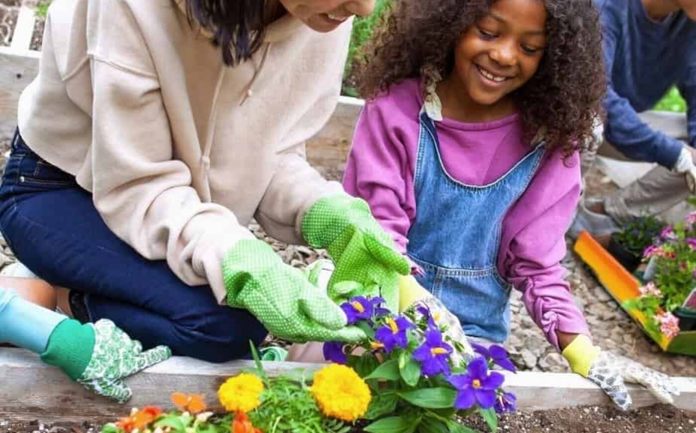 Family planting flowers in their garden